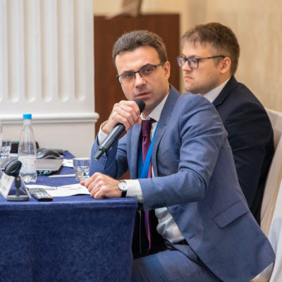 Compressor Technologies Conference 2022. Yu.V. Kozhukhov, Chairman of the Organizing Committee of the Conference, Head of the scientific and engineering group "Compressor, vacuum, refrigeration equipment and gas transportation and processing systems", asks the speakers a question.